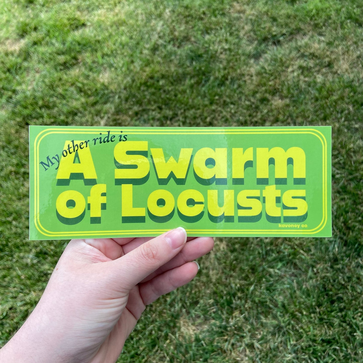 A lime green rectangular vinyl sticker featuring large text that reads “My other ride is A swarm of locusts” in yellow retro-inspired font. The design also features a simple double-line border in a matching yellow.