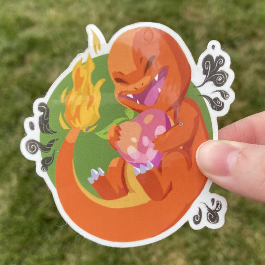 A vinyl sticker of the Pokemon Charmander and a Pecha berry, an in-game item. Charmander is holding the berry in its arms.