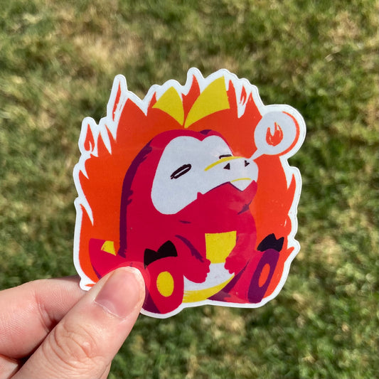 A vinyl sticker featuring an illustration of a cute red pepper crocodile monster! It has a tiny speech bubble with a little flame inside.