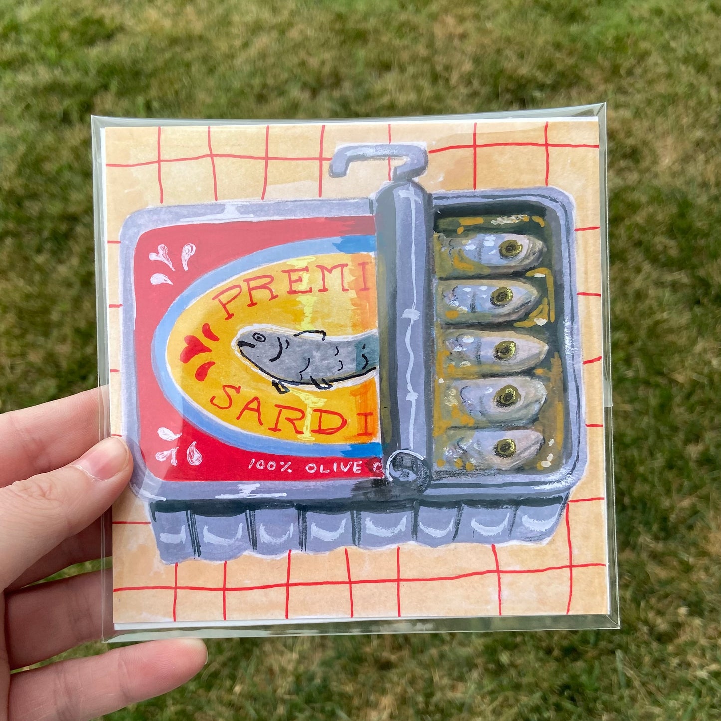 A square-shaped illustration of a yellow and red sardine can, half-open, with a peach and red gridded background.